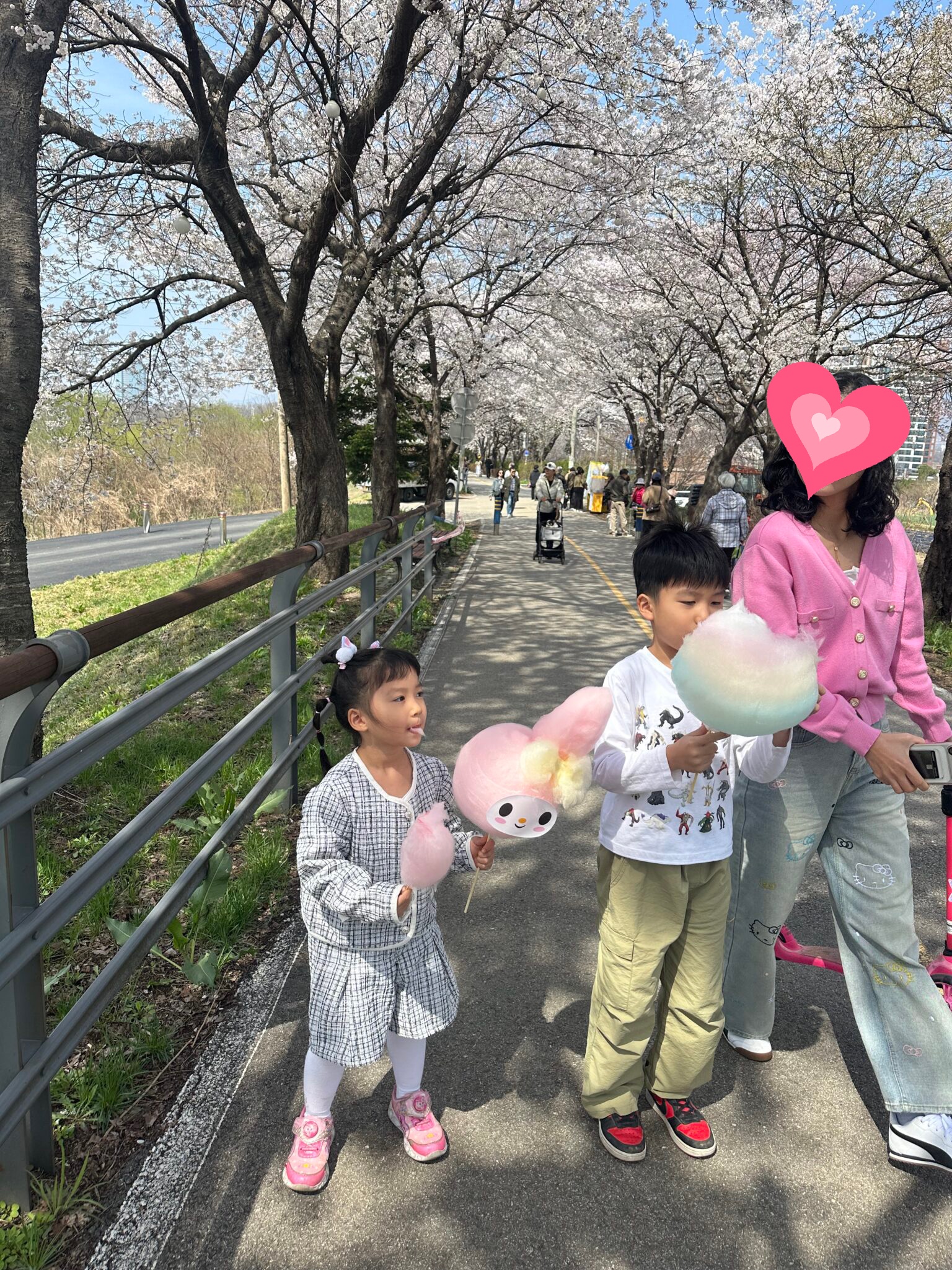 벚꽃 터널 아래 솜사탕을 들고 있는 아이들과 엄마