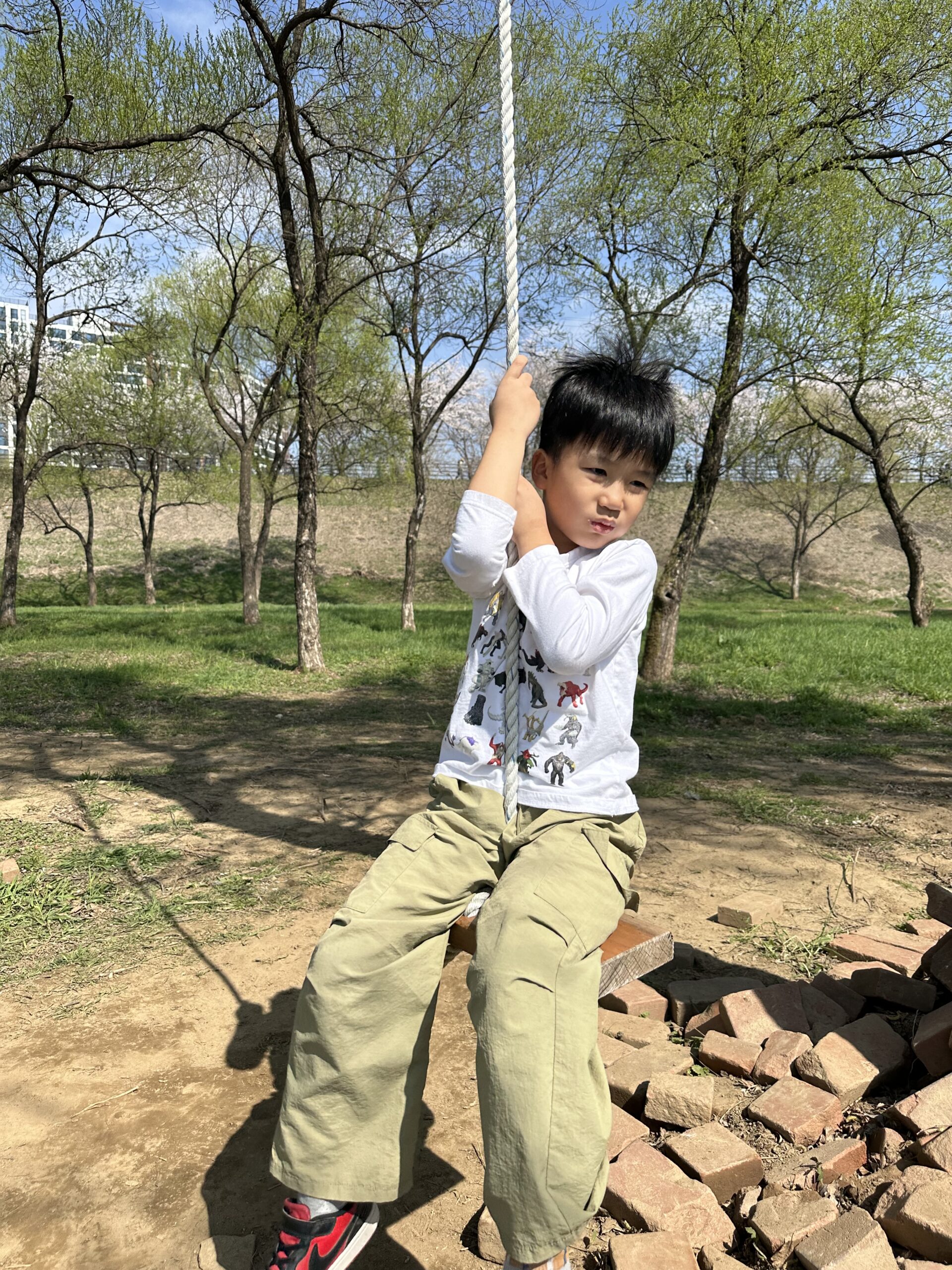 밧줄 그네를 잡고 있는 아들