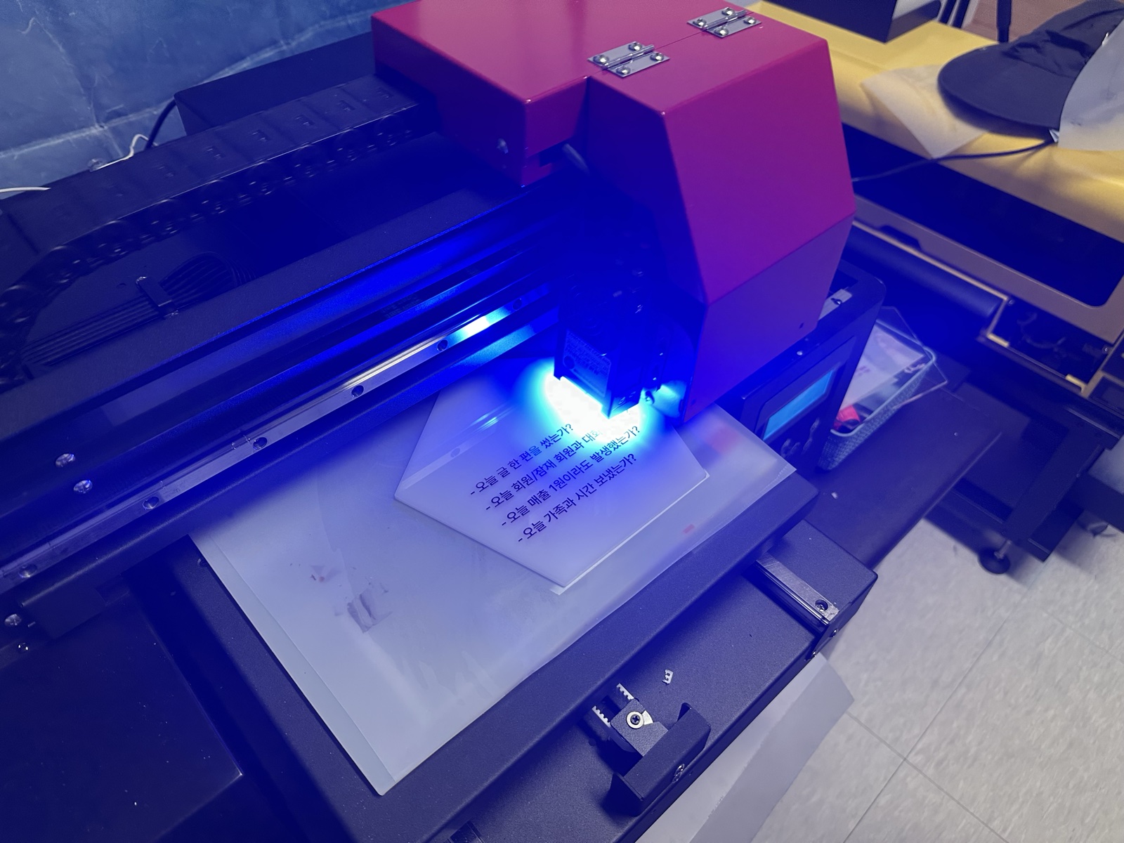 UV 프린터 헤드가 오각형 위에서 첫 글자를 새긴다