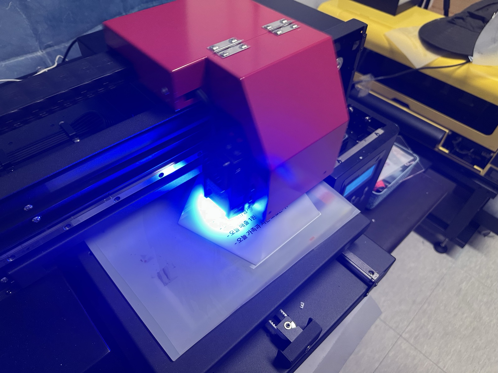 UV 프린터가 오각형 아크릴 패널 위에서 잉크를 분사하기 시작한다